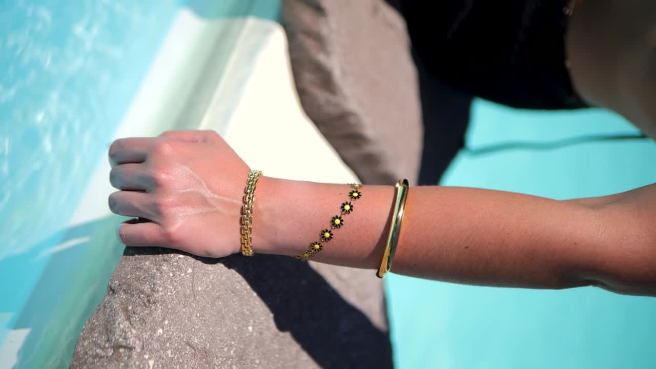 수영장 에서 팔 보석을 조정하는 여성 모델 수직 느린 동작 비디오