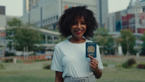 woman holding british passport in a city park
