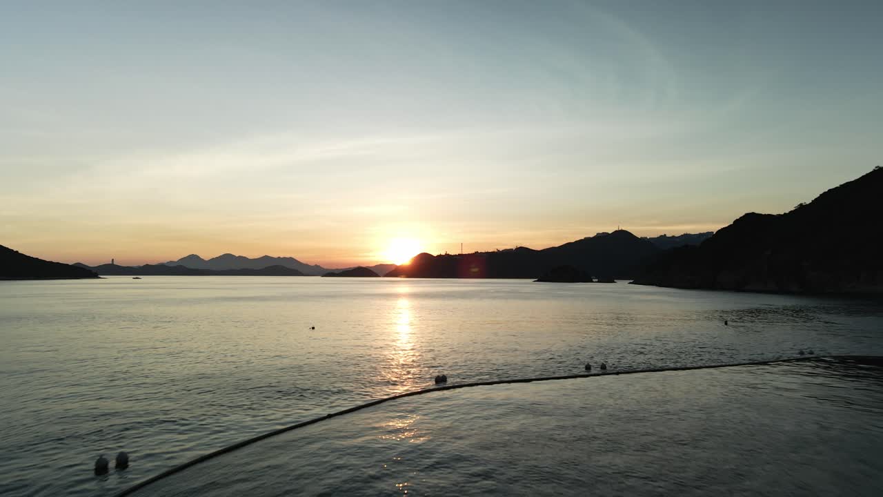 물 위의 낮은 각도로 태양을 향해 날아가는 4k 공중 드론