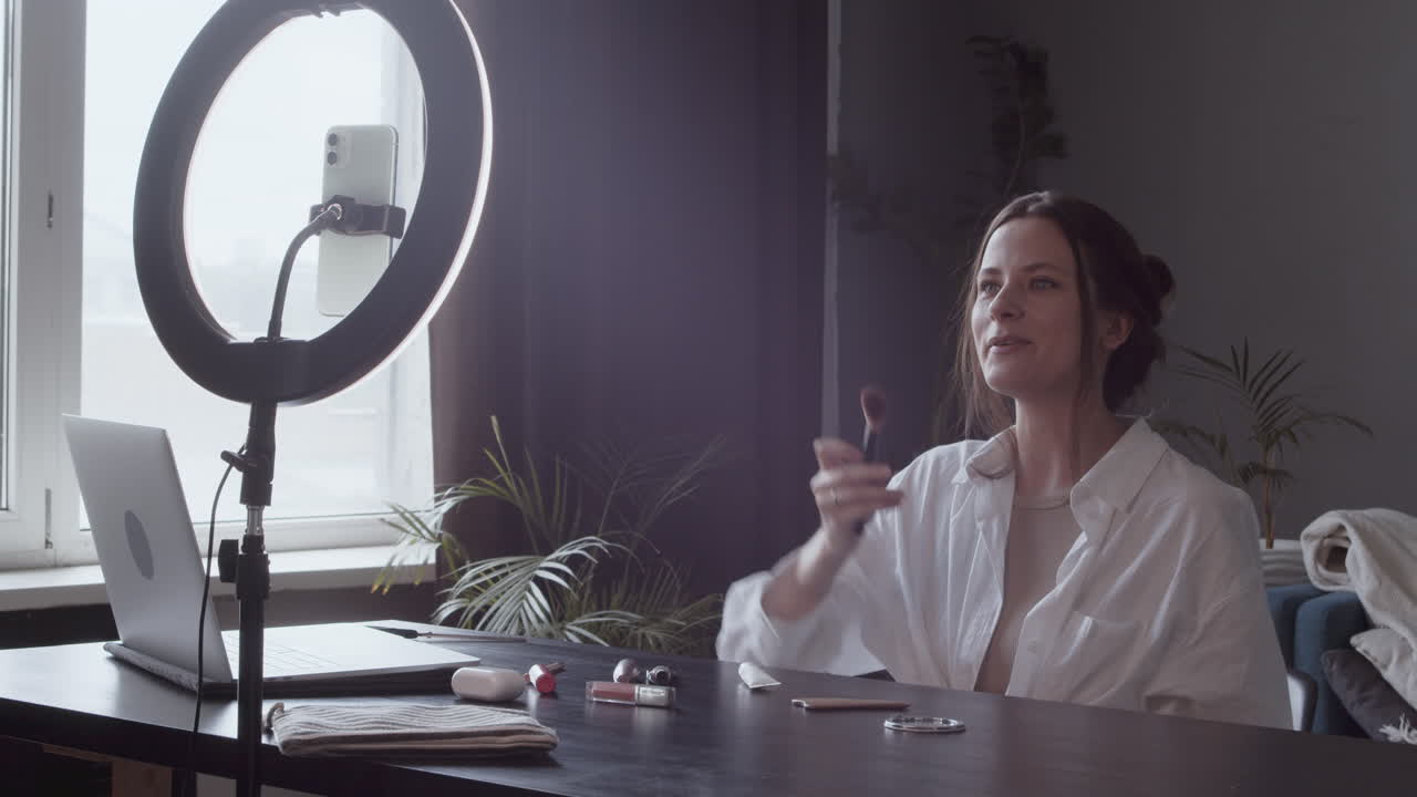 una joven vloguera linda hace una revisión en video de un pincel de maquillaje 1
