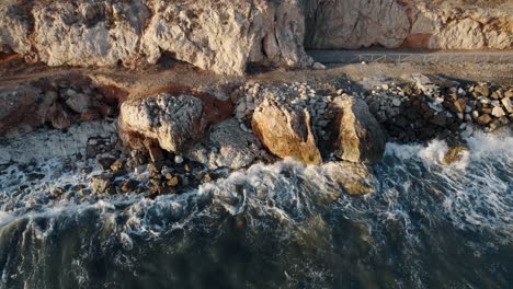 Vista-De-Pájaro-De-Pequeñas-Olas-Rompiendo-En-Las-Rocas-En-El-Mar-Azul,-Peñón,-México