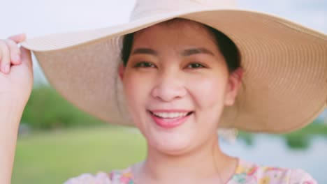 portrait of beautiful asian woman adjusting hat