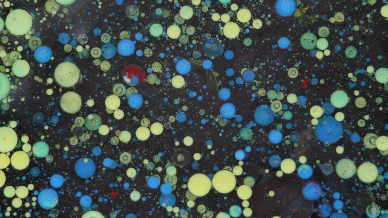 Colorful bubbles. Abstract yellow, blue mixture on a black background. Artistic color paint background.