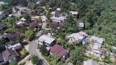 Pueblo-Indio-Con-Carretera-Serpenteando,-Rodeado-De-Exuberante-Vegetación-De-Bosque-Tropical,-Imágenes-De-Drones