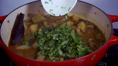 Añadiendo-Cilantro-Y-Perejil-A-Una-Olla-De-Curry-De-Papaya-Verde-Y-Papaya-Fresca-Orgánica-Amarilla-Madura-Y-Fresca