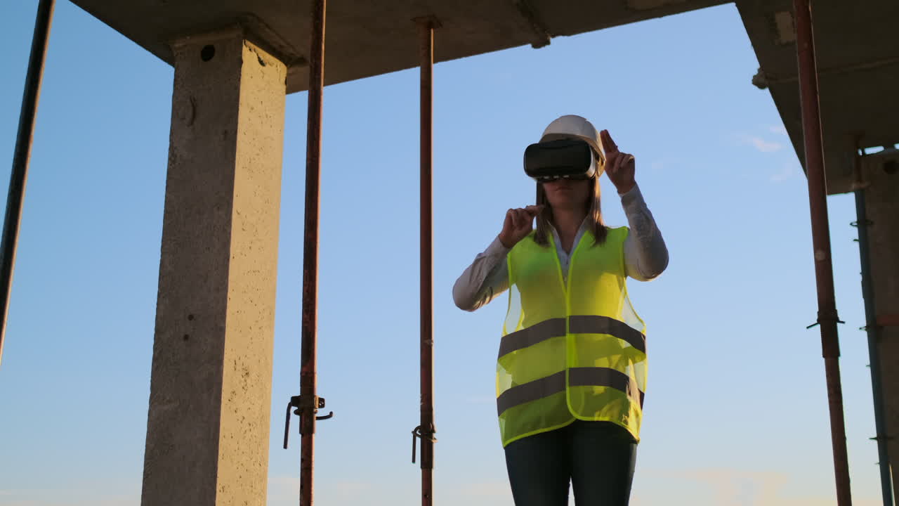 una mujer ingeniera en un sitio de construcción en gafas de realidad virtual mueve sus manos simulando el trabajo de la interfaz del futuro control innovador de la construcción de edificios