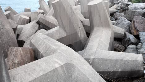 Concrete-formed-coastline-defence-geometric-shape-engineering-lying-on-shoreline