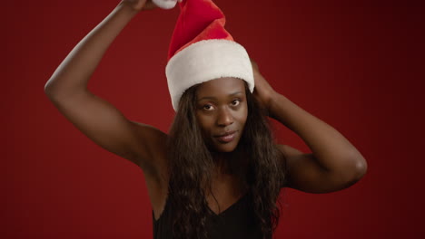 young woman puts a santa hat on