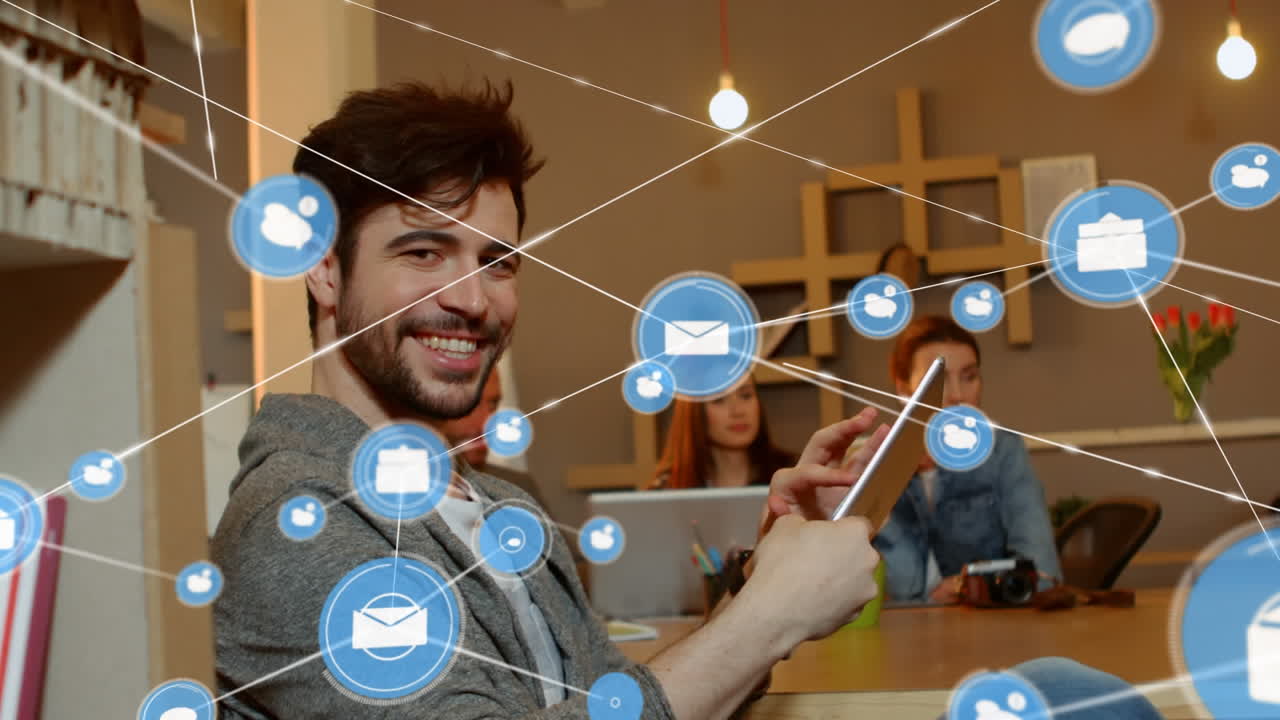 animación de una red de iconos digitales sobre el retrato de un hombre caucásico feliz usando una tableta en la oficina