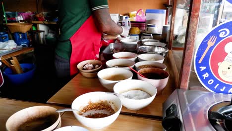 chef preparing noodle bowls at a street food stall