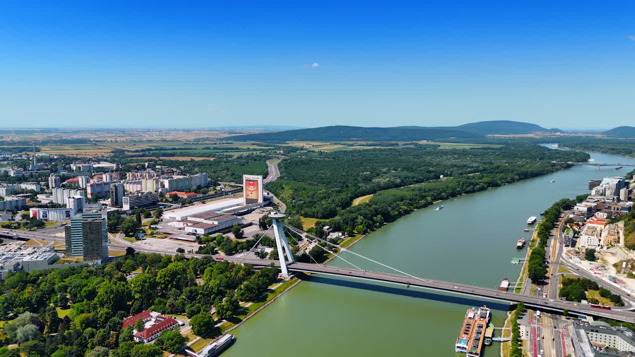 Bratislava, Slovakia - June 14, 2025: Bratislava's Danube view. Overlooking the Danube River in Bratislava, the green landscape contrasts with modern city structures nearby