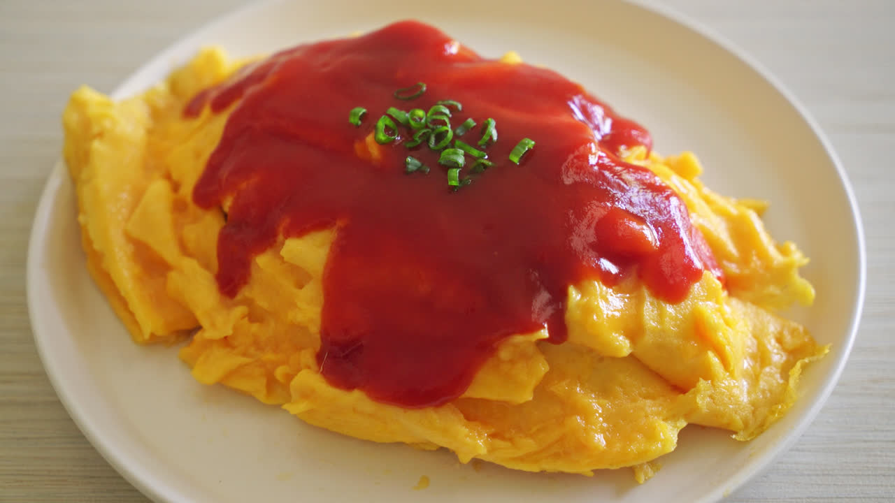 arroz frito aromatizado en una envoltura de tortilla o omurice al estilo japonés - estilo de comida asiática