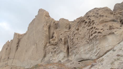 Slow-tracking-shot-of-volcanic-white-cliffs-formation-in-Santorini-island,-Greece