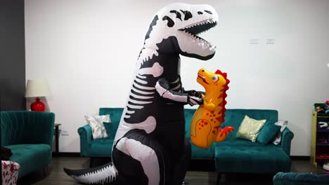 halloween dinosaur costume with man in the living room of the house with a little dinosaur