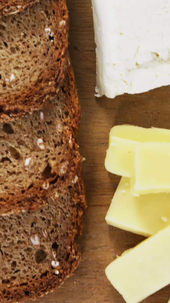 Selezione di formaggi con pane integrale su tagliere di legno