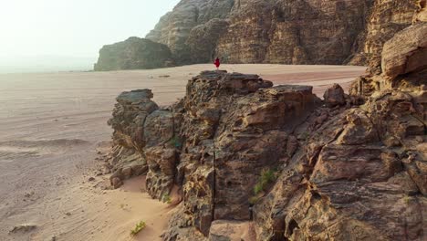 A-Woman-Standing-Over-Geological-Rock-Formations-Of-Wadi-Rum-In-Jordan,-Middle-East