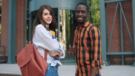 caucasian woman and african american man talking in the street near the university