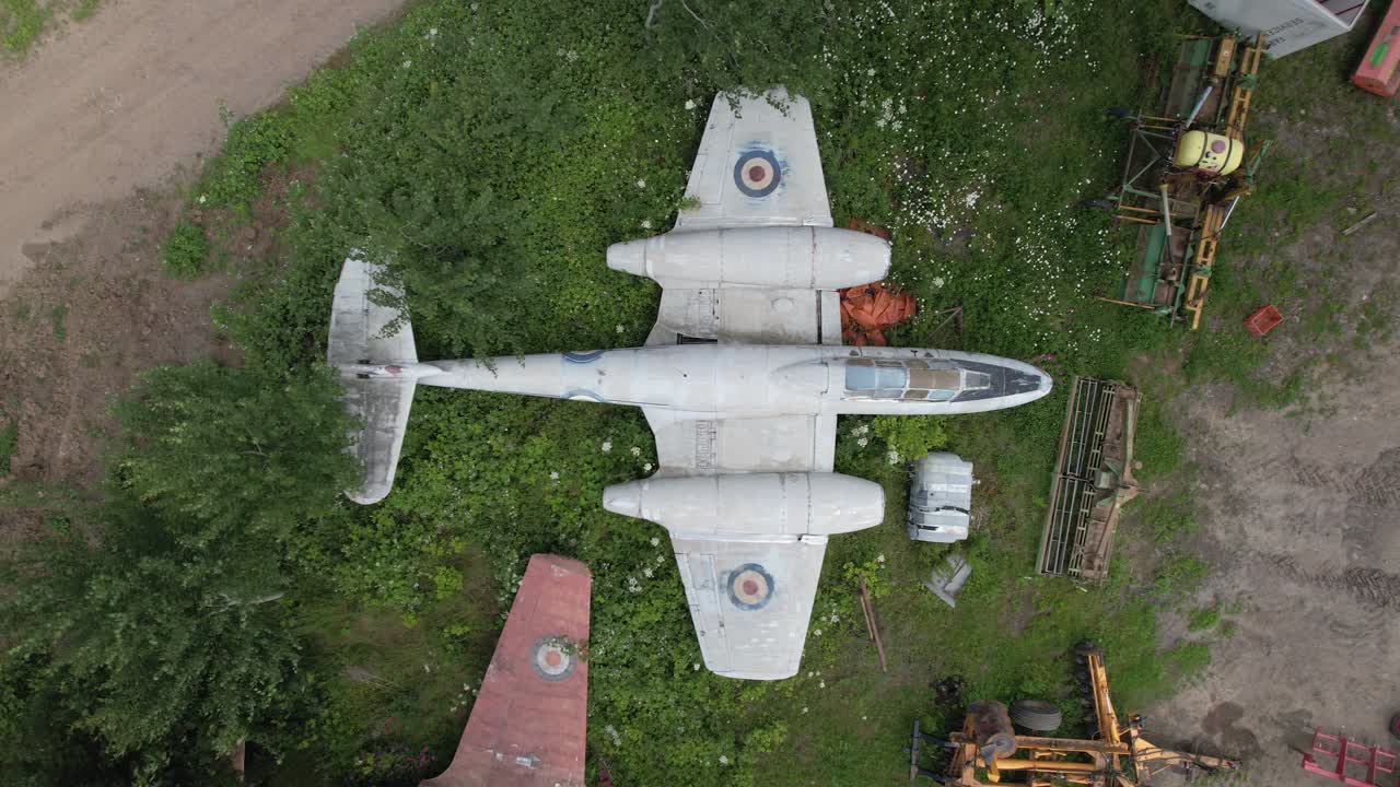 воздушный снимок винтажного военного самолета gloster meteor raf, припаркованного среди зелени в английской деревне - кинематографический кадр сверху вниз