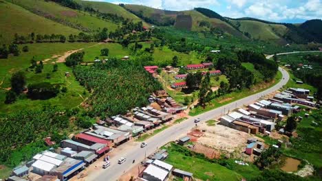 Scenic-African-Road-Surrounded-With-Lush-Green-Mountains-In-Western-Uganda---aerial-shot