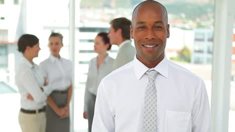 business man smiles as he looks at the camera