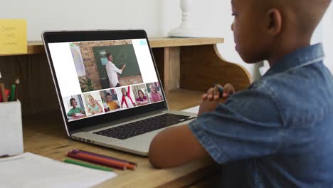 Niño-Afroamericano-Sosteniendo-Un-Lápiz-Teniendo-Una-Videoconferencia-En-Una-Computadora-Portátil-En-Casa