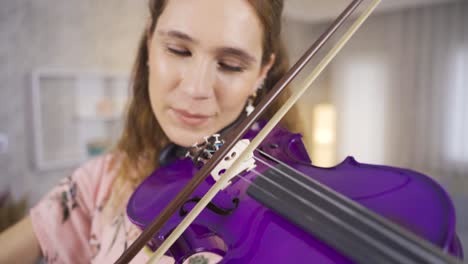 primer plano de una mujer músico tocando el violín en casa, componiendo, tocando música.