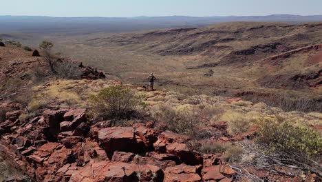 Drohne-Umkreist-Aufnahme-Eines-Mannes,-Der-Auf-Bergen-In-Der-Wüste-Westaustraliens-Wandert