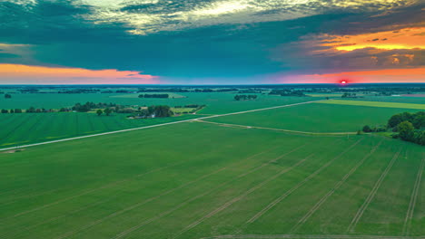 sunset over farmland crops in spring - aerial panorama hyper lapse