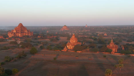 Aerial-flight-showing-plains-of-Bagan-with-Dhammayangyi-Temple-and-scattered-smaller-temples-in-the-light-of-the-setting-sun---Myanmar,Asia