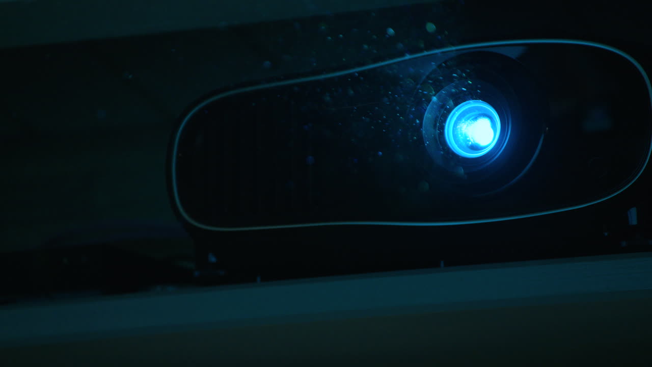 FOCUS PULLS out and in of dust particles in front of a home cinema projector