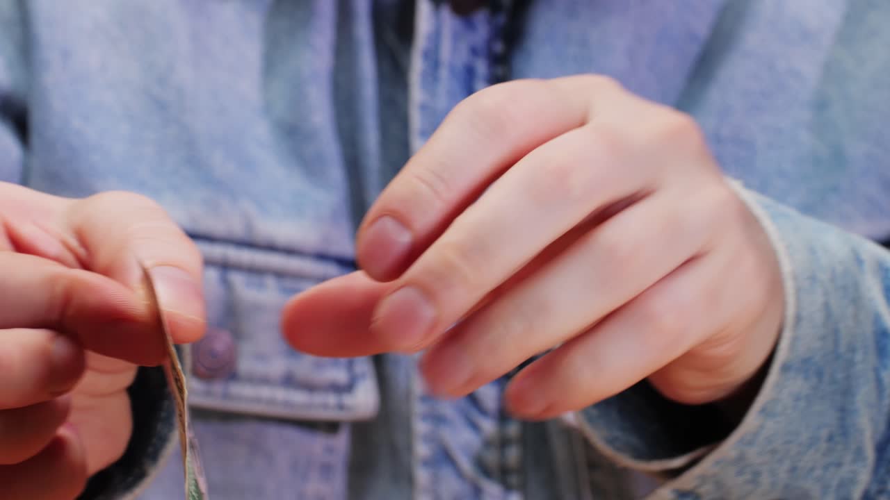 A closeup and detailed view of a fiftydollar bill being held in hands, showcasing its intricate design and features