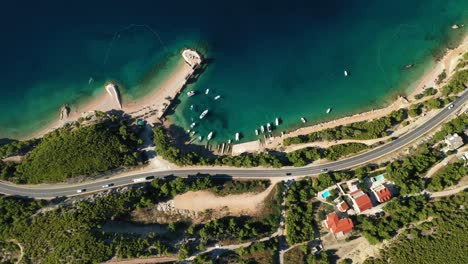 aerial drone footage of cars driving on a coastal road across the screen in croatia