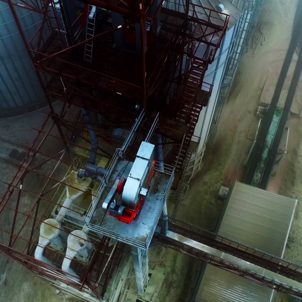 Metal tower constructions with ladders climbing up to the tops of elevator tanks. Silo elevator from the bird's eye view