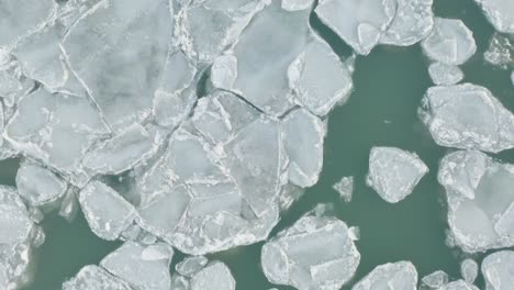 Drohnenaufnahme-Aus-Der-Luft-Zeigt-Gefrorene-Eisbrocken,-Die-Im-See-Schwimmen