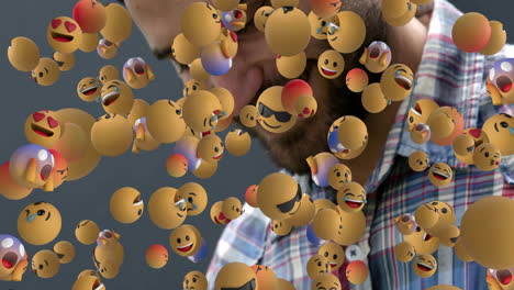 man facing camera while yellow 3d emoji icons floating over gray backdrop, highlighting technology