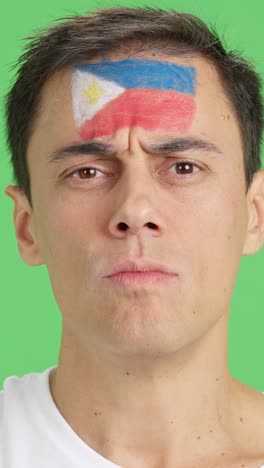 serious man with a philippine flag painted on the face