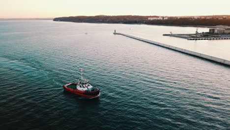 drone flying around the fishing boat sailing on the sea at the sunset