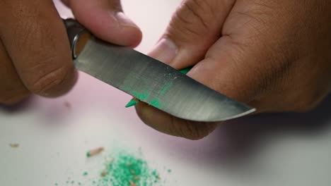 Footage-of-hands-slowly-sharpening-a-pencil-and-some-coloured-pencils-with-a-sharp-knife