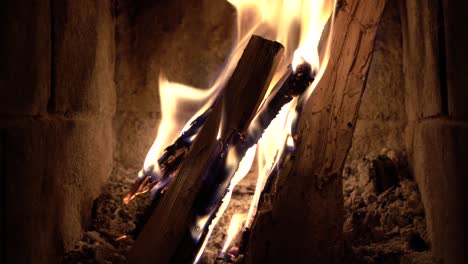 Mittlere-Aufnahme-Von-Holzscheiten,-Die-In-Einem-Innenkamin-Brennen