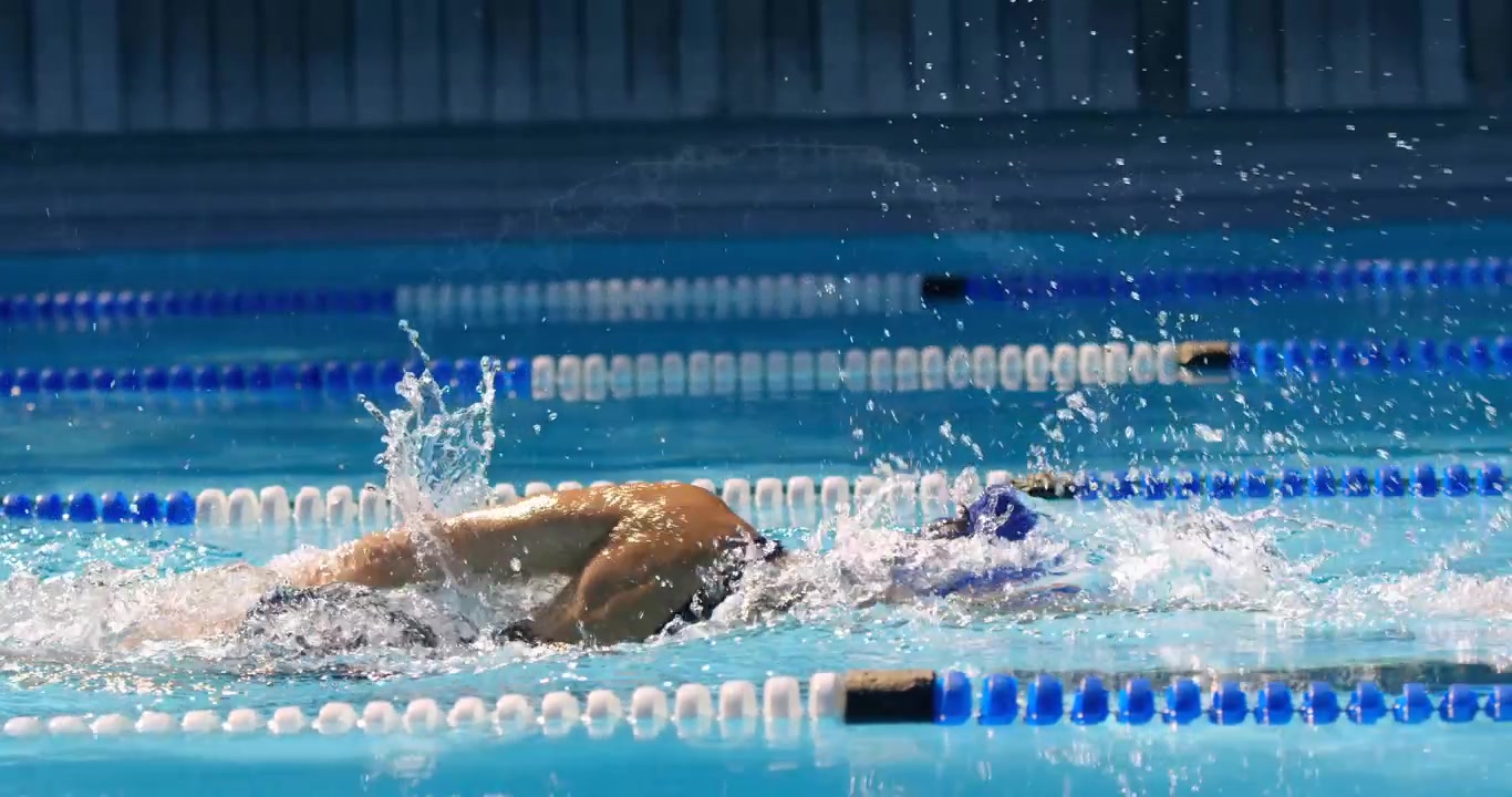 Faint digital globe grid appearing over pool wall initiating swimmer freestyling in sports pool