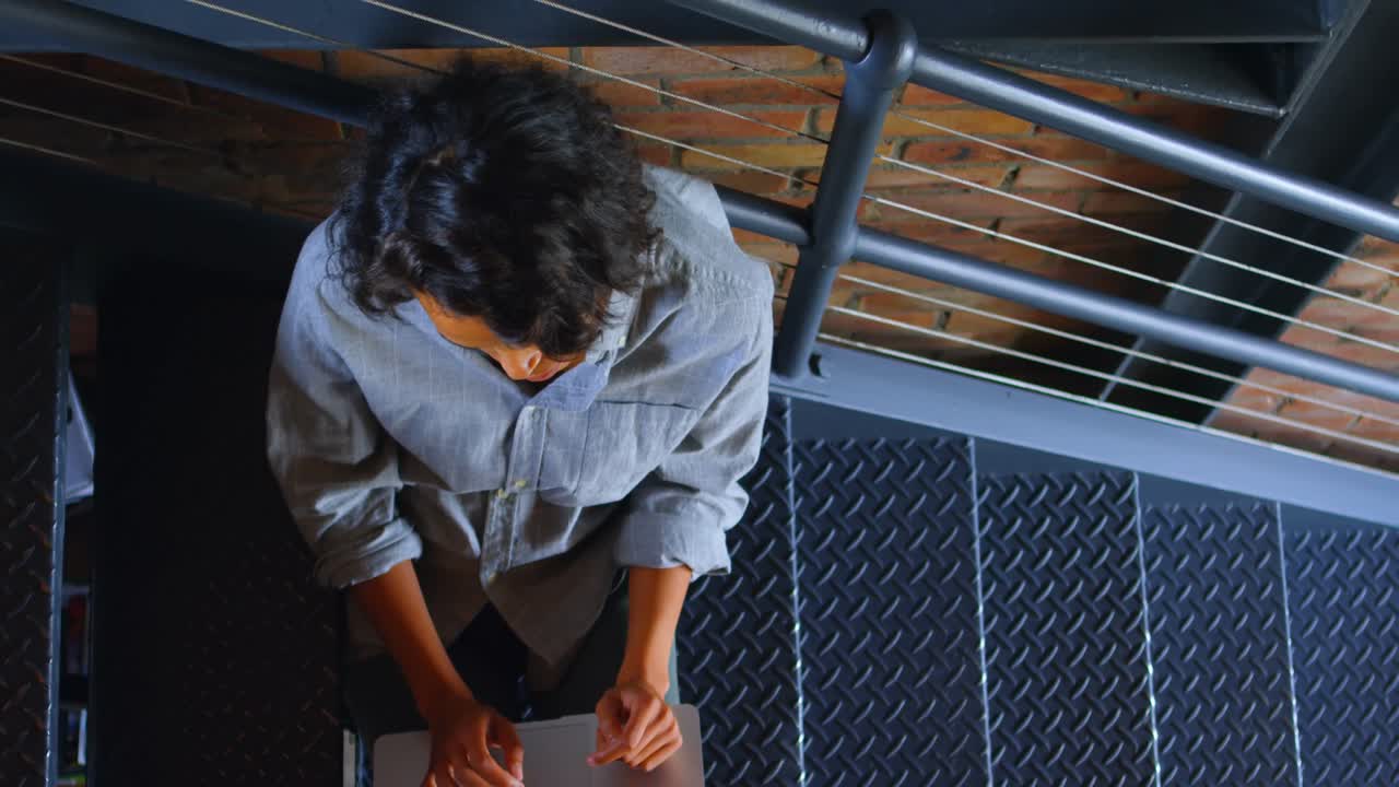 mujer usando computadora portátil en la escalera en casa 4k