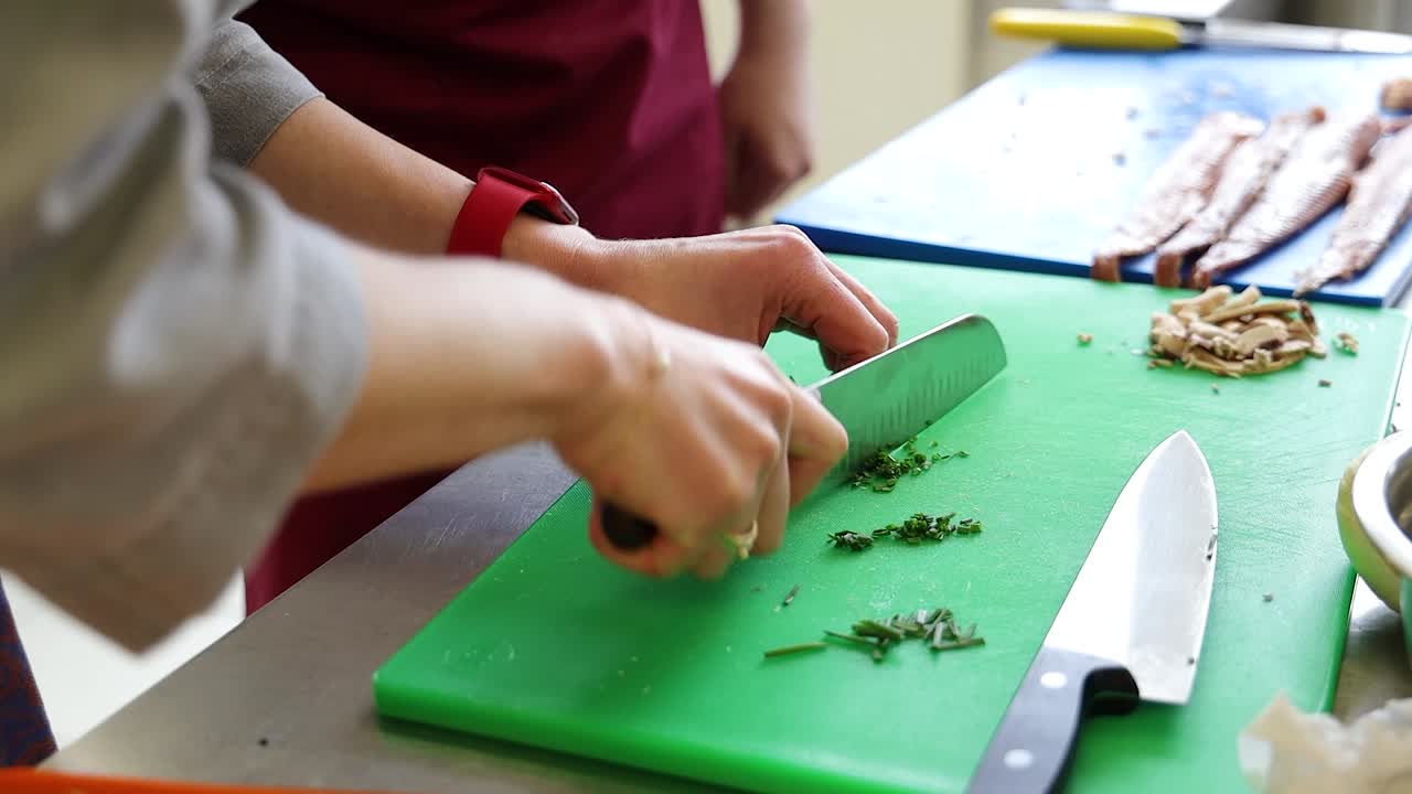 шеф-повар режет зелень на кухне ресторана