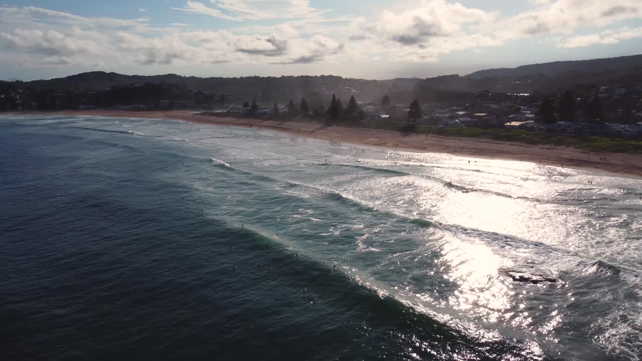 Naturskjønt dronebilde fra luften av North Avoca-stranden med surfere som venter på ettermiddagsbølger, Central Coast NSW Australia 4K
