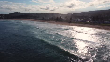 Toma-Aérea-De-Paisaje-Escénico-De-Drones-De-La-Playa-De-Avoca-Del-Norte-Con-Surfistas-Esperando-Las-Olas-De-La-Tarde-Costa-Central-Nsw-Australia-4k