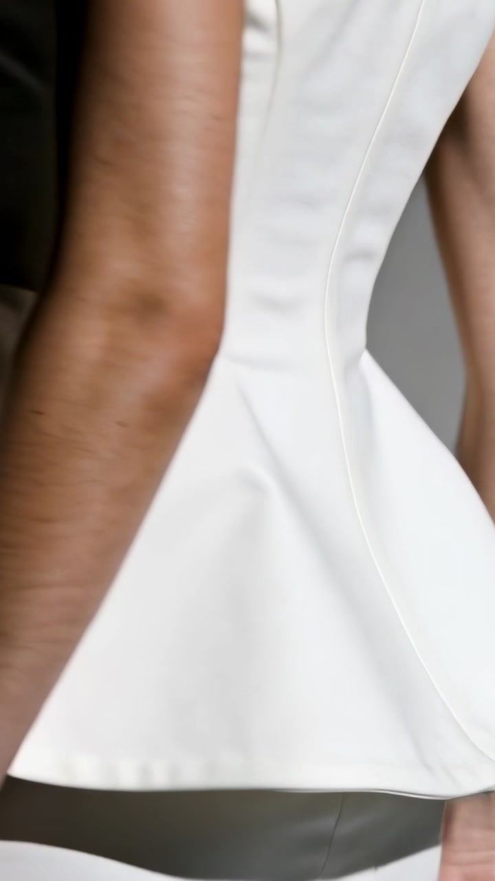 Vertical video: Pulling back, model rotating torso showing boned top and peplum for studio showcase