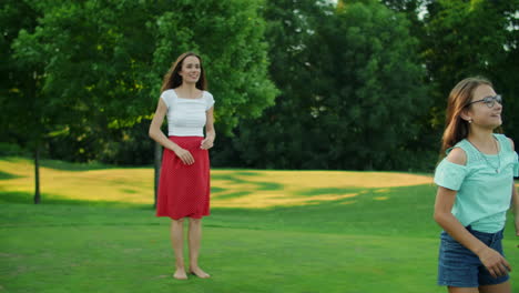 Parents-and-kids-playing-with-ball-in-green-meadow.-Boy-and-girl-jumping-in-air