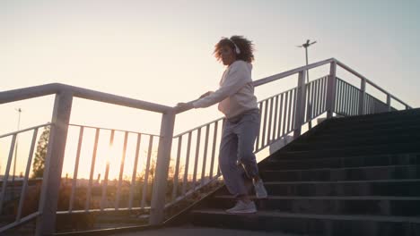 wide shot  of black woman dancing on the bridge and looking at camera