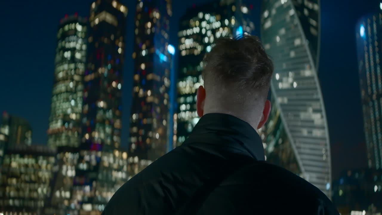 Person looking at the city skyline at night