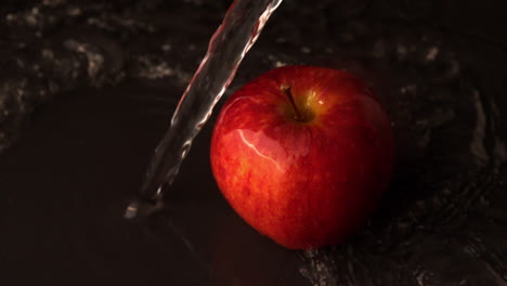 el agua se vierte sobre la manzana roja.