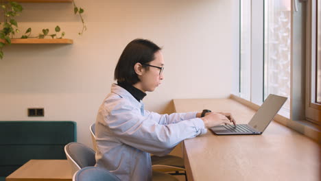 concentrated man working on laptop computer in a coffee shop